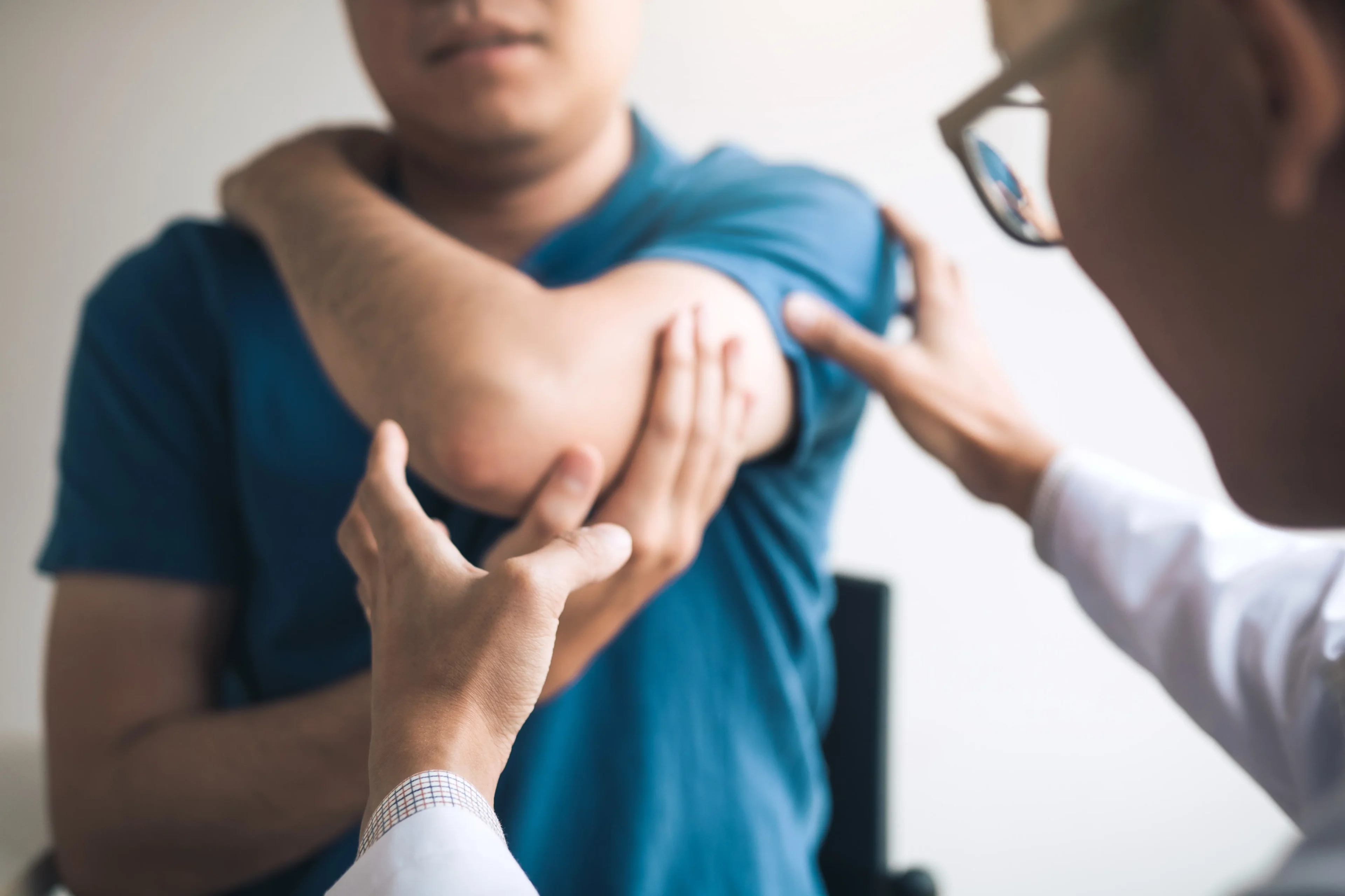 Doctor examining patient's elbow.