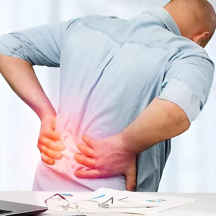 Man with lower back pain holding his side.