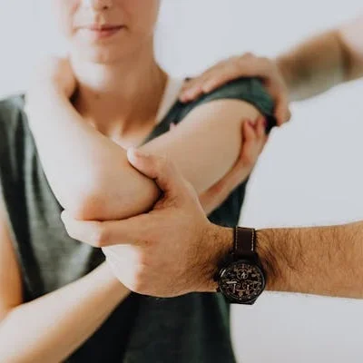 Person receiving elbow examination by doctor.