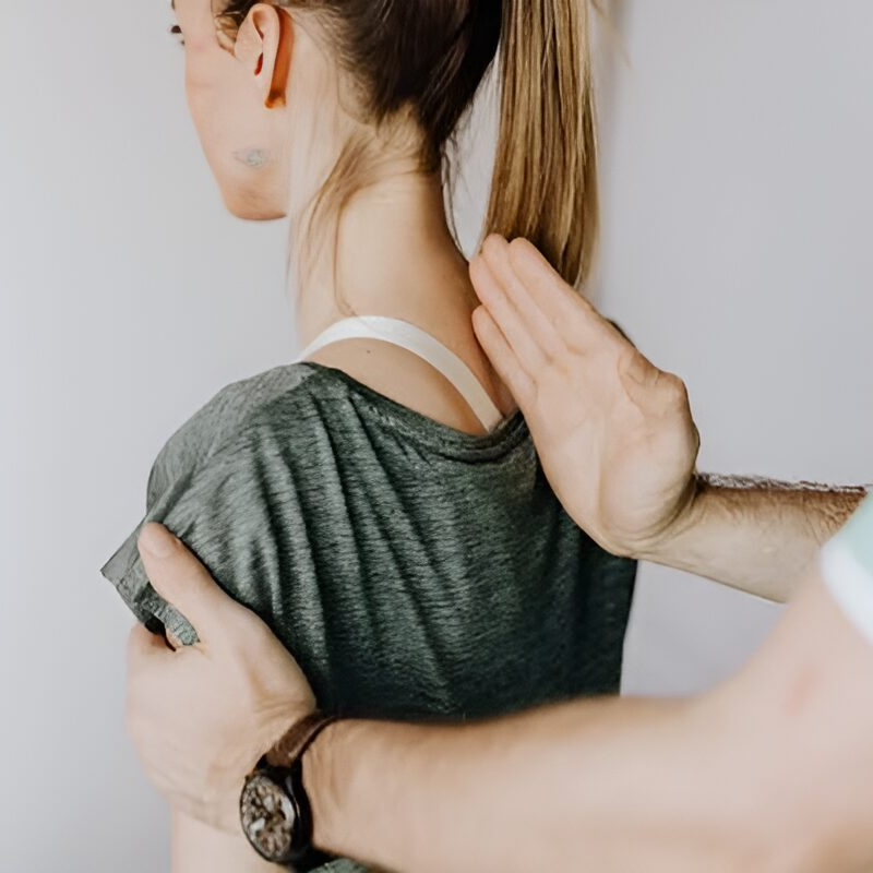 Woman receiving shoulder massage from therapist.