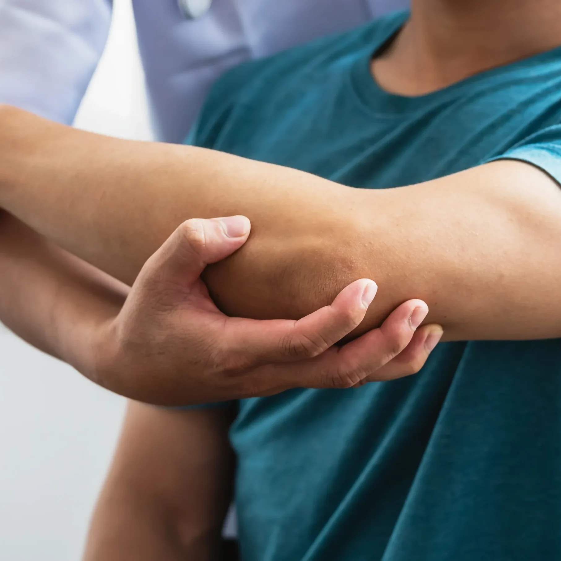 Doctor examining patient's elbow.